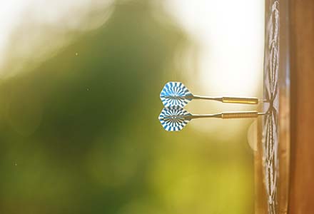 Two darts stuck in the middle of a dart board