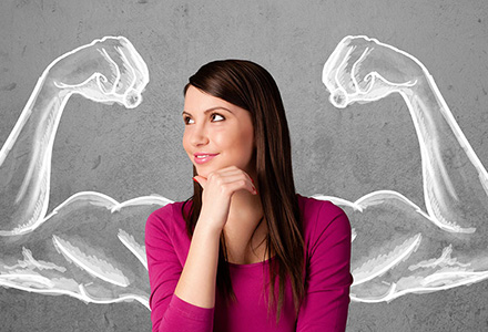 Woman standing in front of chalk outline of muscle-filled biceps in strong man pose