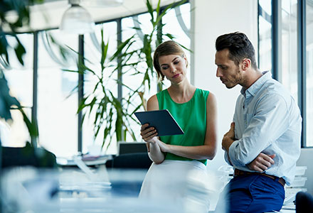 Photo of business people looking at a tablet in an office