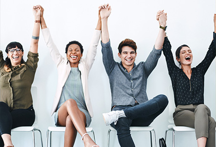 group of people holding their hands in the air