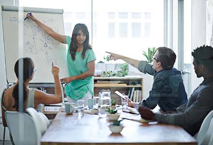 Group of people in a conference room referencing a pie chart