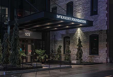 Exterior entryway lit sign at night for McKnight Foundation