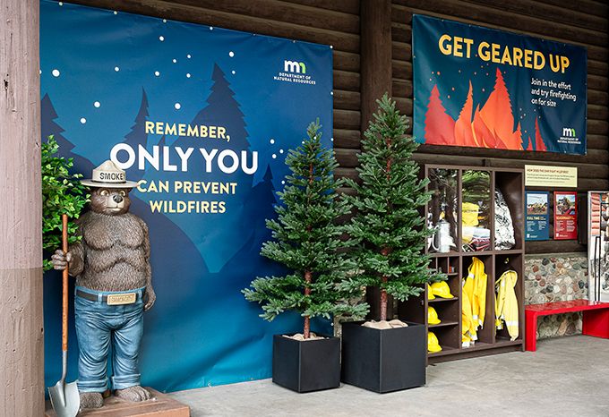 Selfie station and gear station with Smokey Bear statue at the DNR Fire Prevention area at the Minnesota State Fair